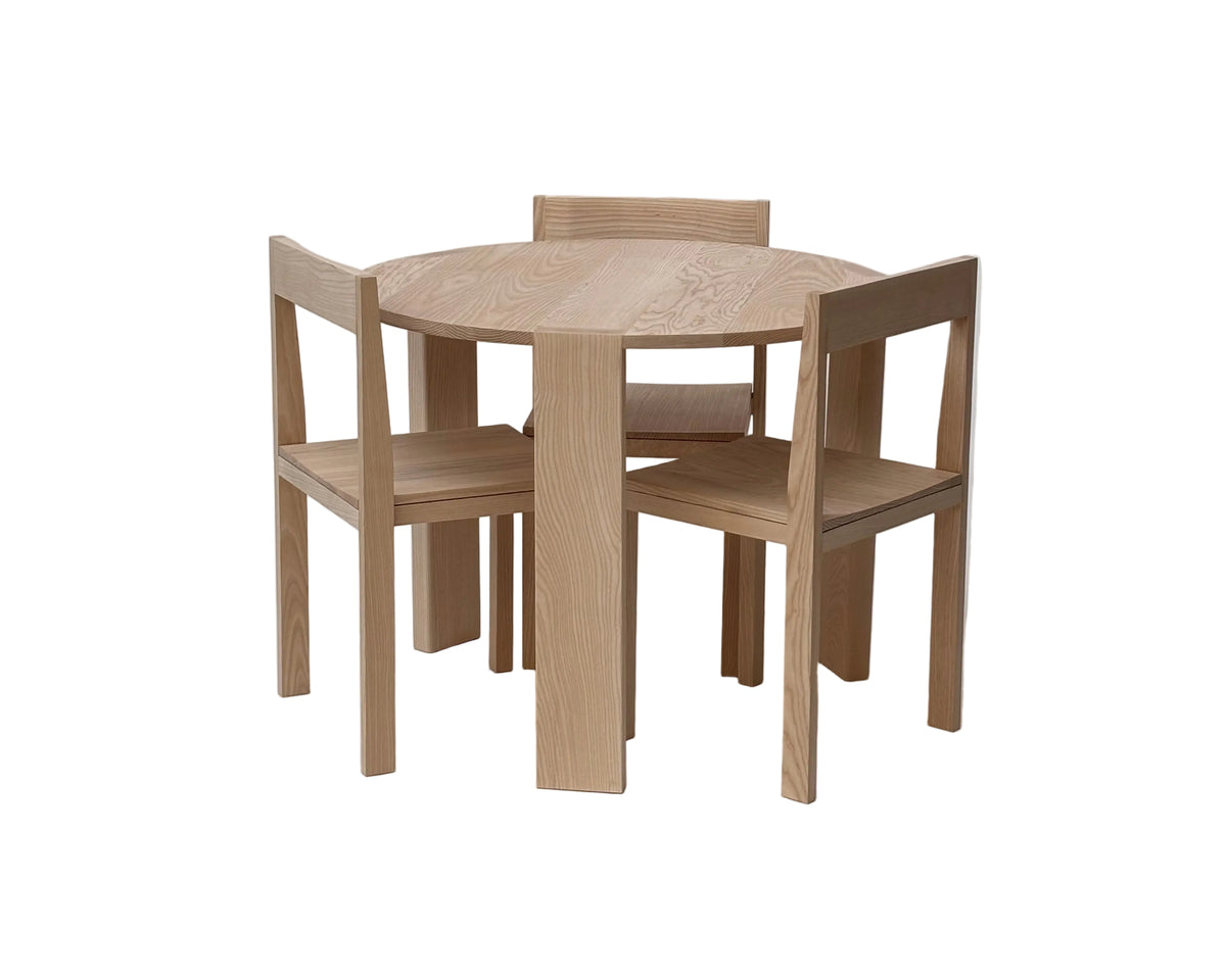 Round Table 01 in ash surrounded by Chair 01 dining chairs